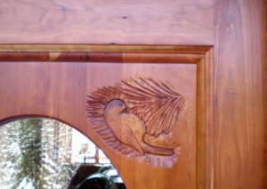 Carving of a chickadee on a custom built cherry entry door