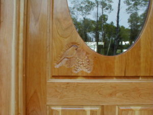 Custom cherry enrtry door with chickadees and pinecones carved in