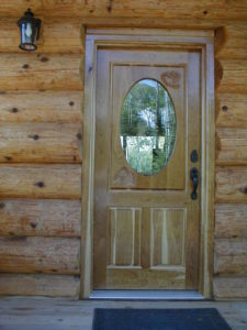 Custom cherry enrtry door with chickadees and pinecones carved in