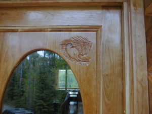 Custom cherry enrtry door with chickadees and pinecones carved in